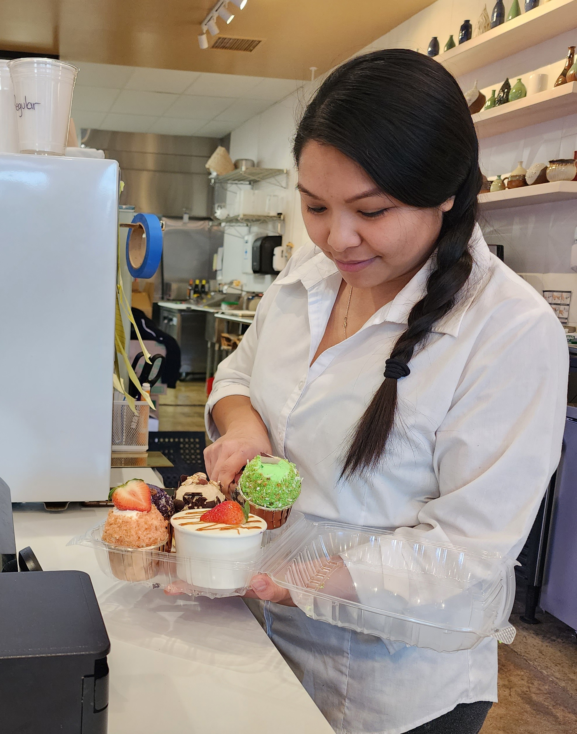 Owner in their shop organizing to-go cupcakes
