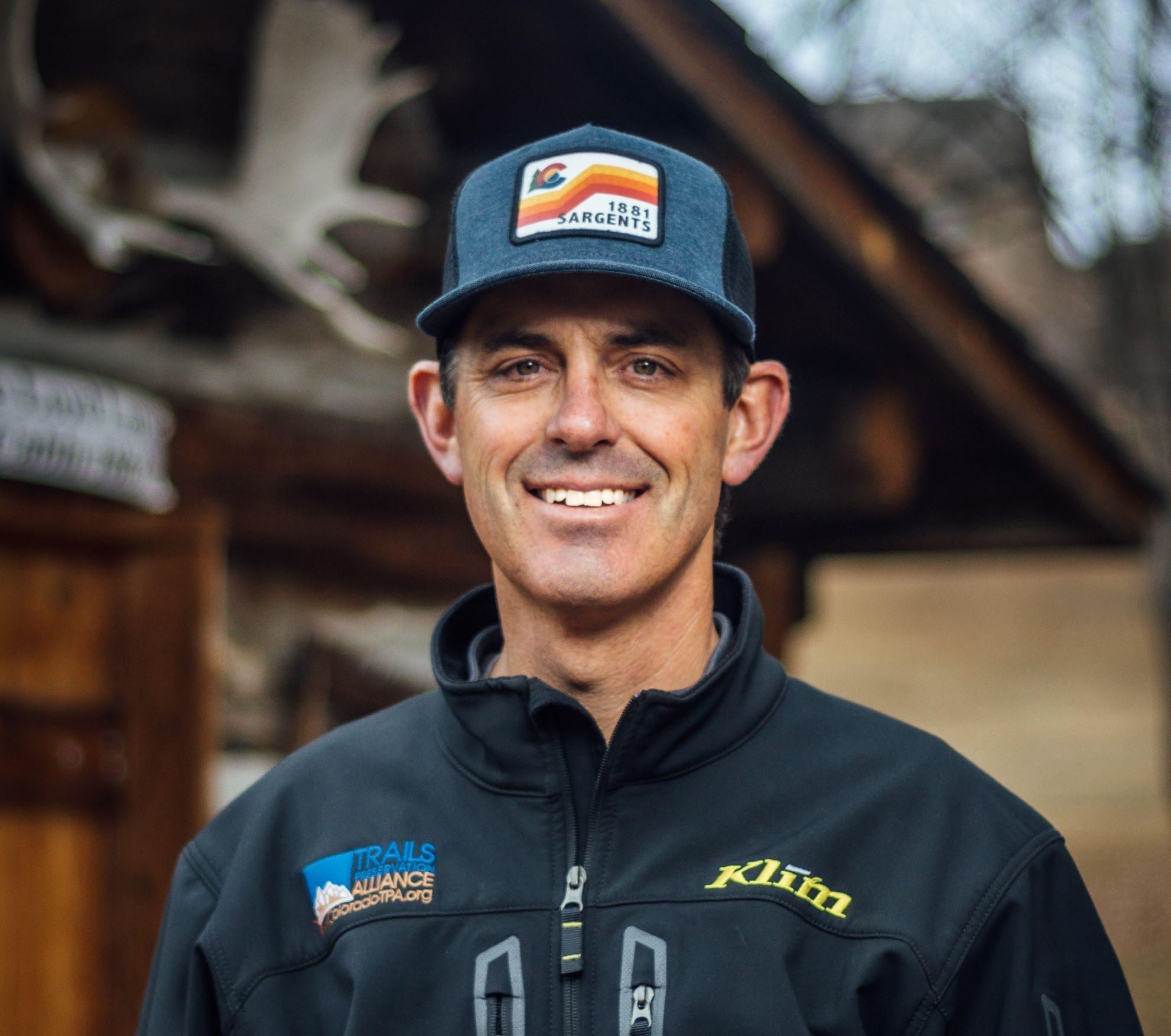 Chad Hixon headshot, smiling wearing a blue and grey jacket.