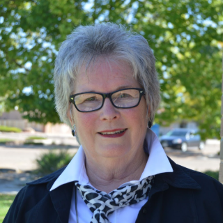 Headshot of Julie Worley, who is smiling, wearing glasses.