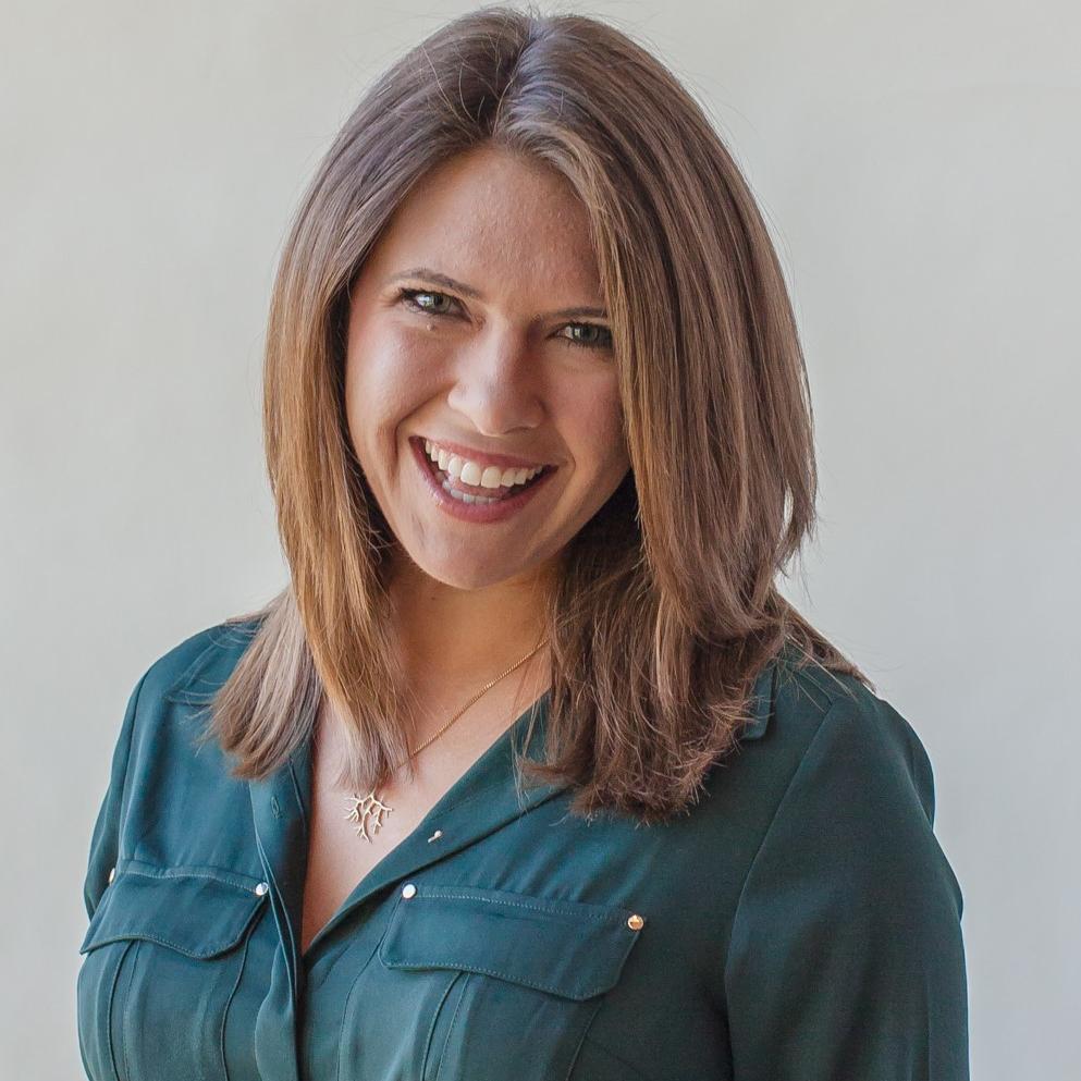 Headshot of Liz Agostin, smiling, green blouse, gold necklace