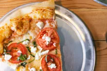 slice of margarita pizza on silver plate