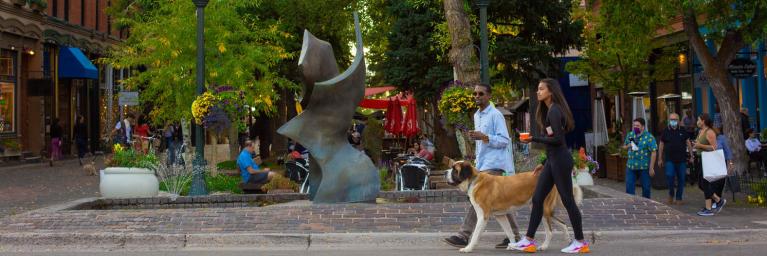 Walking a dog eating ice cream in down town Aspen. 