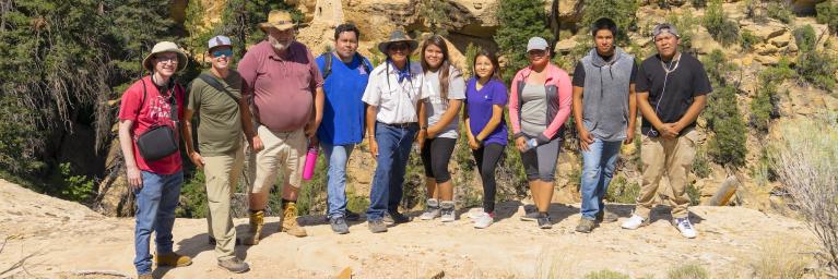 Group of people in front of rocky landscape