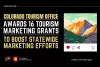 Press release graphic from the Colorado Tourism Office announcing 16 tourism marketing grants to enhance statewide marketing efforts, featuring a social media post with a  stylized illustration of Colorado mountains at sunrise.