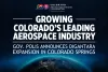 Promotional graphic titled 'Growing Colorado's Leading Aerospace Industry' from the Colorado Office of Economic Development and International Trade, announcing Governor Polis's announcement of the Dignatara expansion in Colorado Springs, with a backdrop of Earth from space